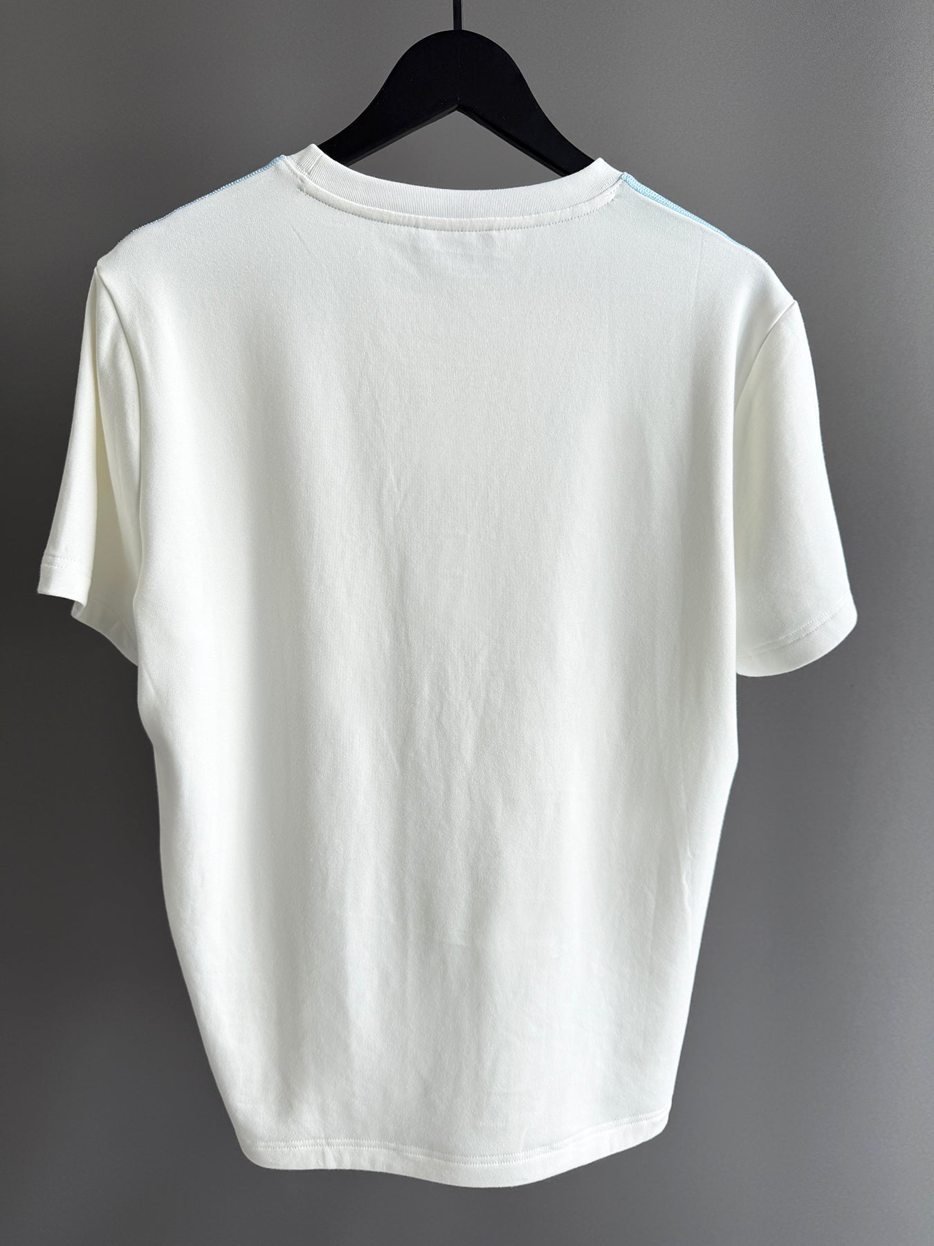 Contrast blue topstitching off white tee shirt