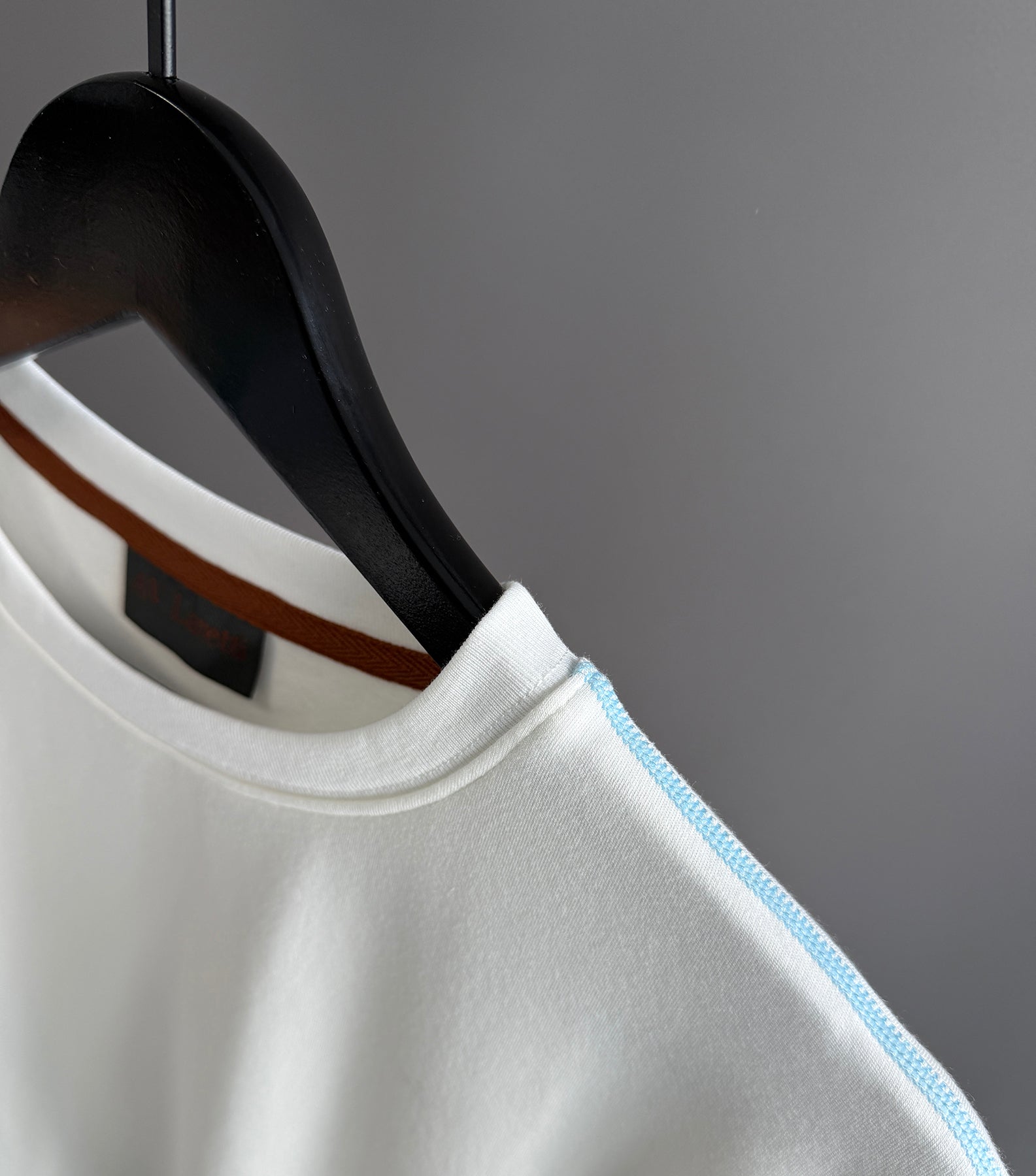 Contrast blue topstitching off white tee shirt