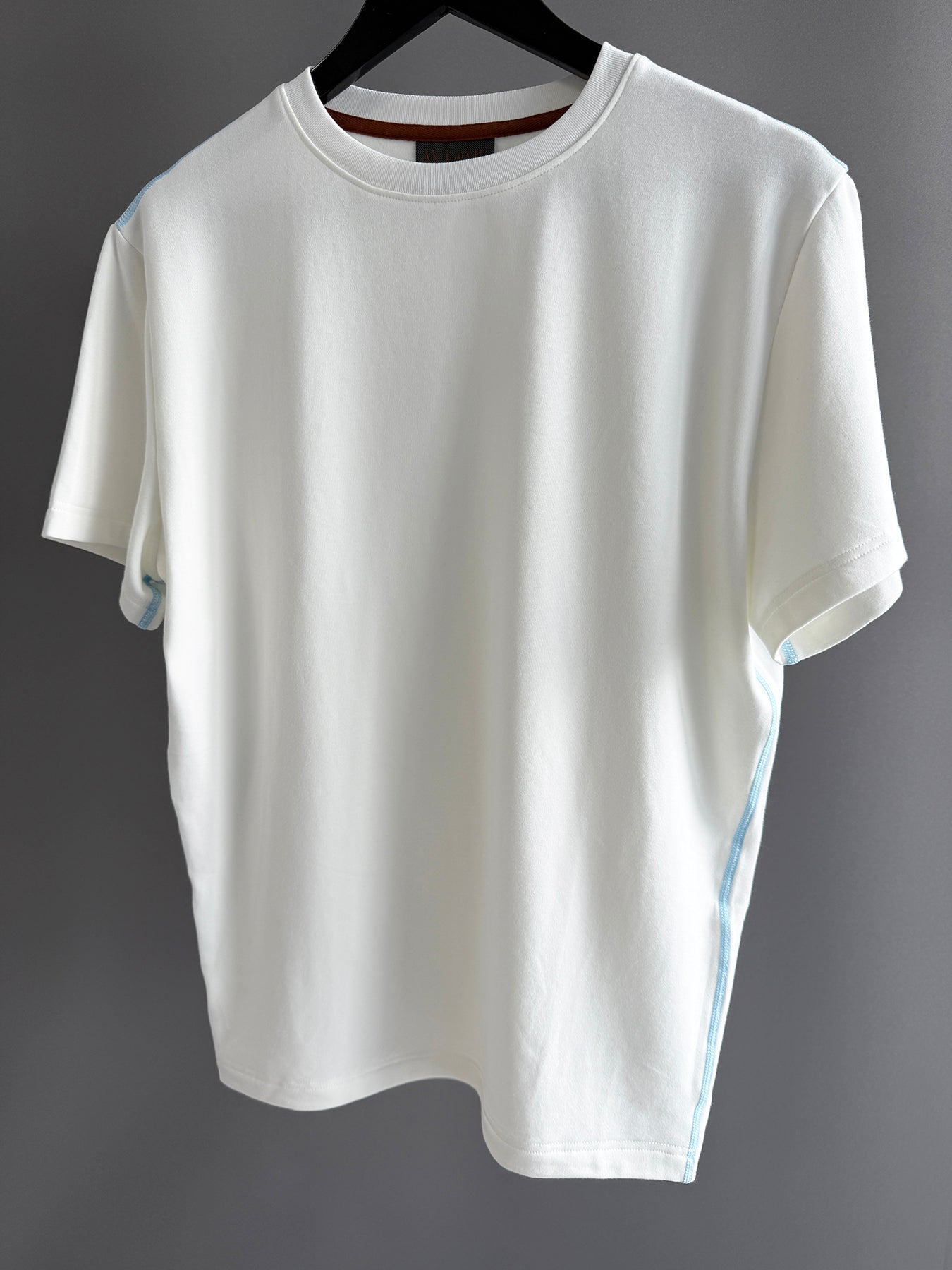 Contrast blue topstitching off white tee shirt