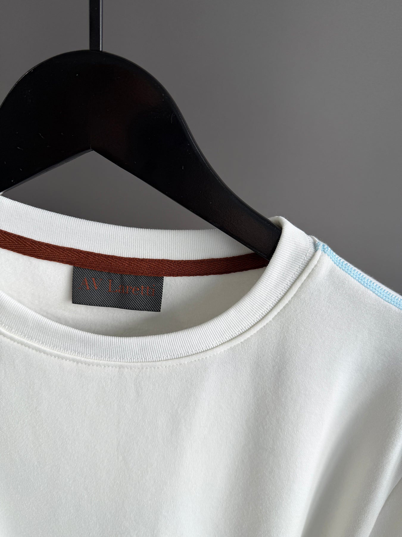 Contrast blue topstitching off white tee shirt