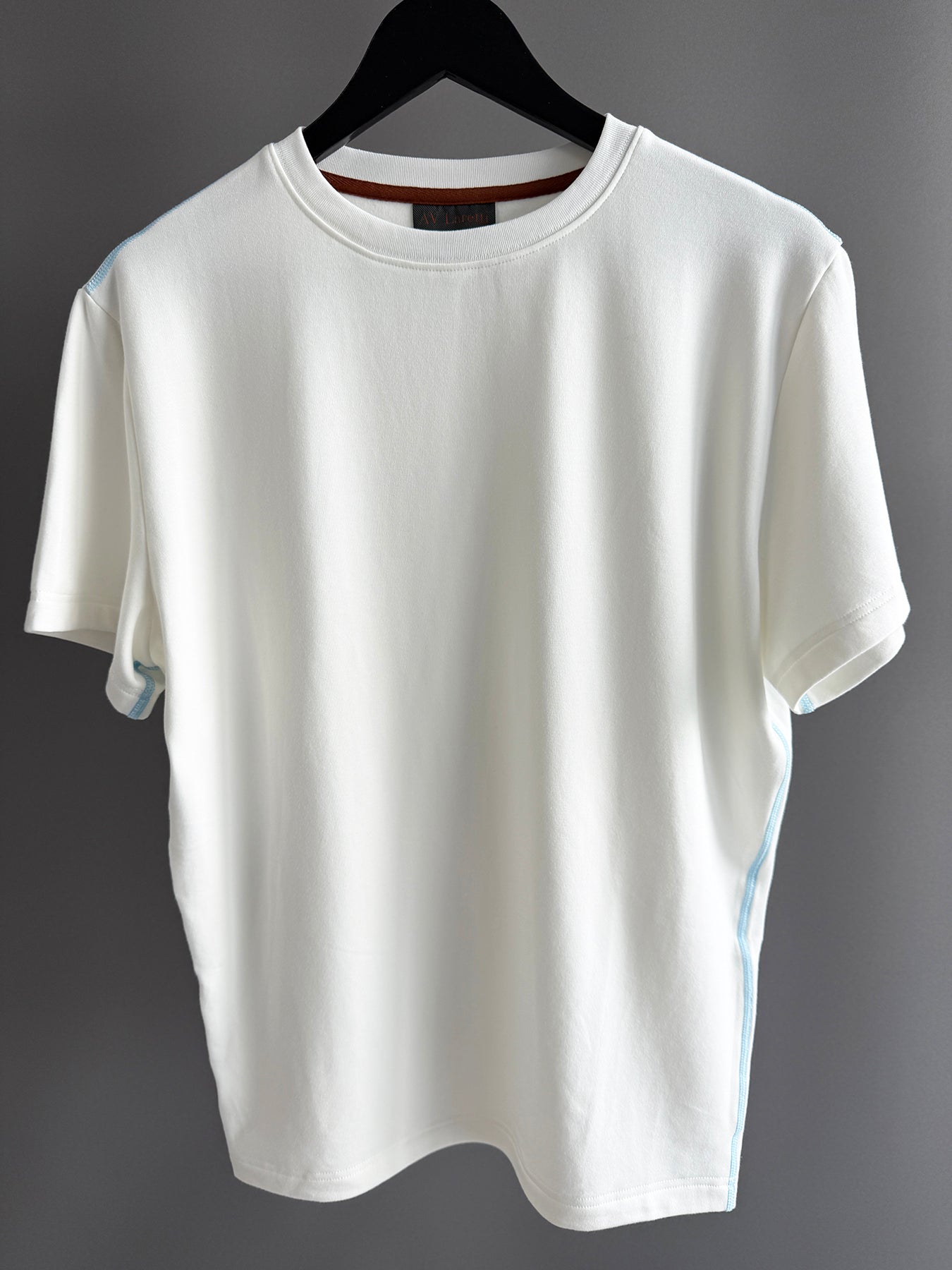 Contrast blue topstitching off white tee shirt